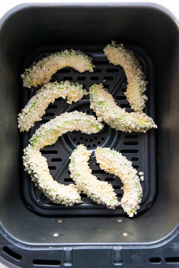 Arranging 8 avocado slices in a single layer in the air fryer 