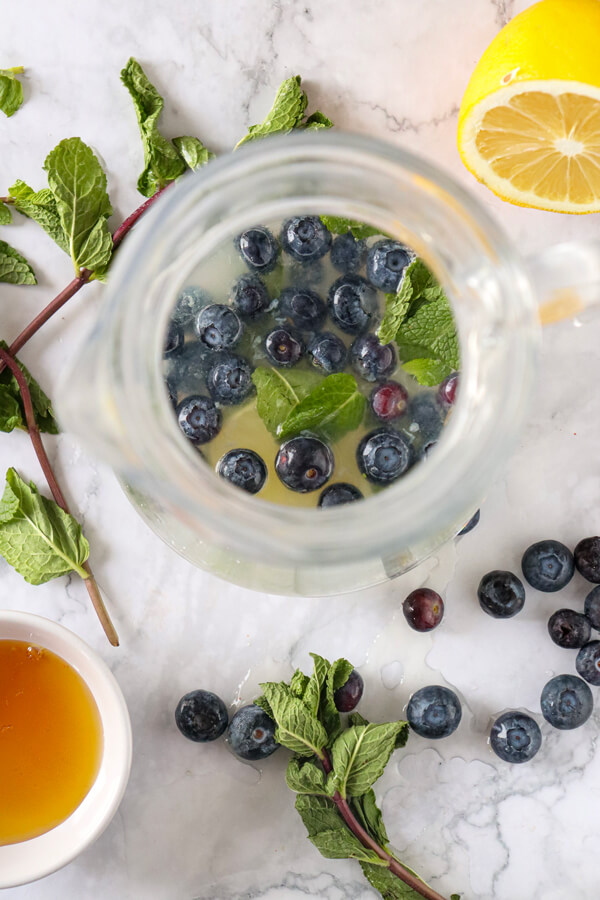 Jug with blueberries, mint leaves, and lemon juice