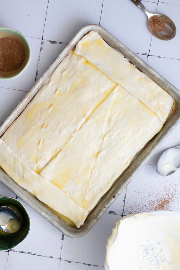 Adding another layer of crescent roll dough and melted butter