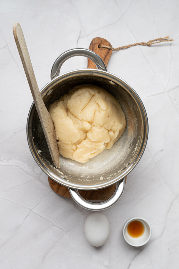 Adding the flour and stirring until the dough forms a smooth ball