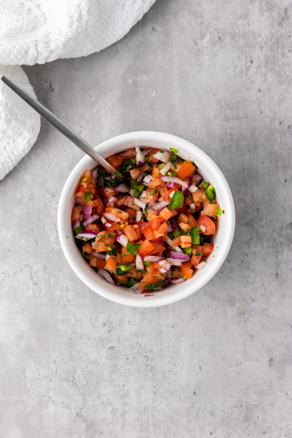 Combining all the veggies with lime juice, salt, and pepper
