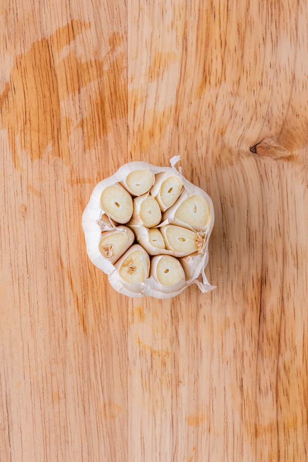 Cutting the top off a whole garlic bulb