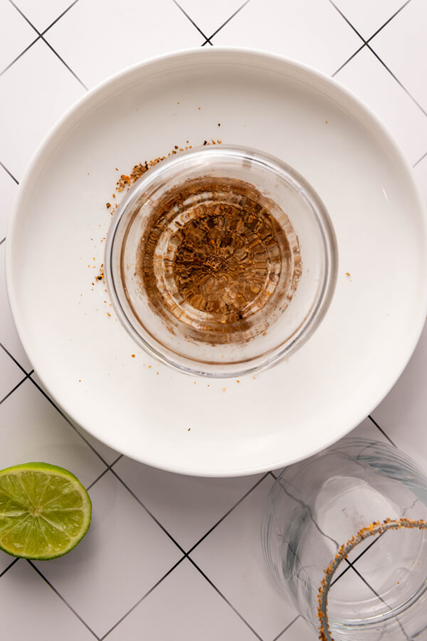 Covering a glass rim with lemon and tajin
