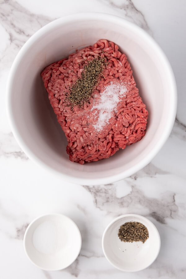 Mixing salt and pepper into the ground beef