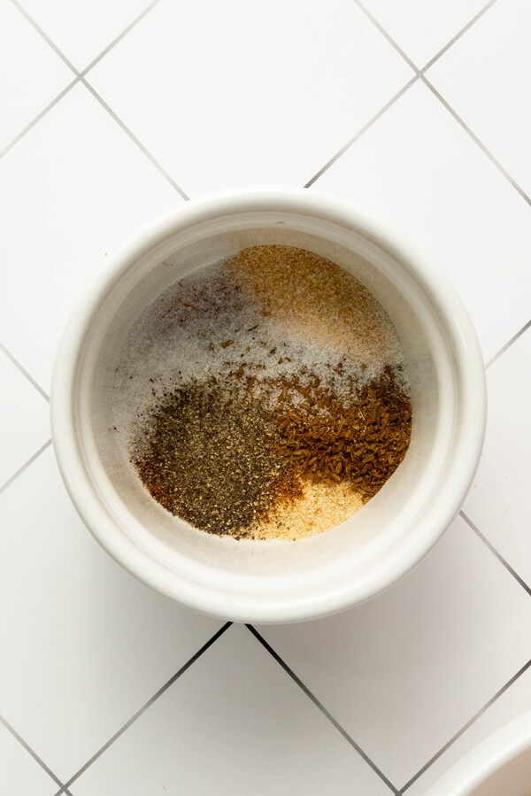 Mixing the paprika, garlic powder, onion powder, cumin, cayenne, salt, and black pepper