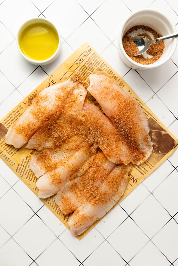 Rubbing the tilapia with oil and the spice mixture