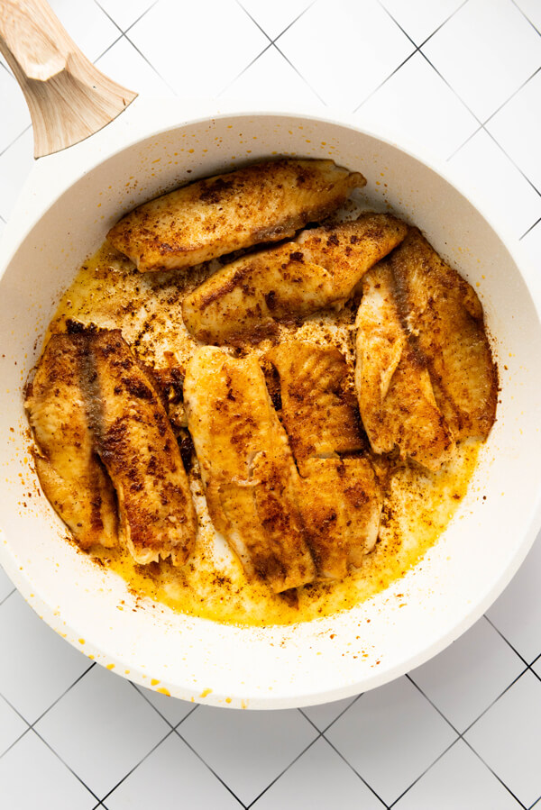 Cooking the tilapia on a skillet