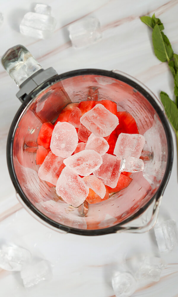 Adding honey and ice cubes into the blender