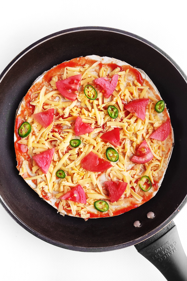 Adding tomato slices and chili pepper slices