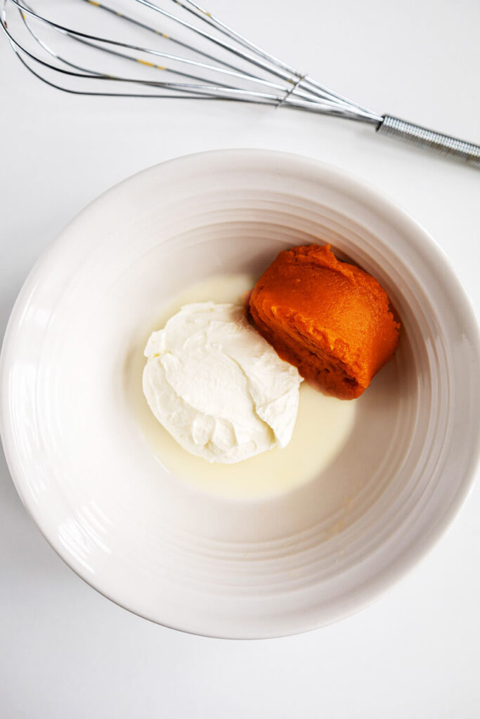 Mixing cream cheese, powdered sugar, pumpkin puree, and milk