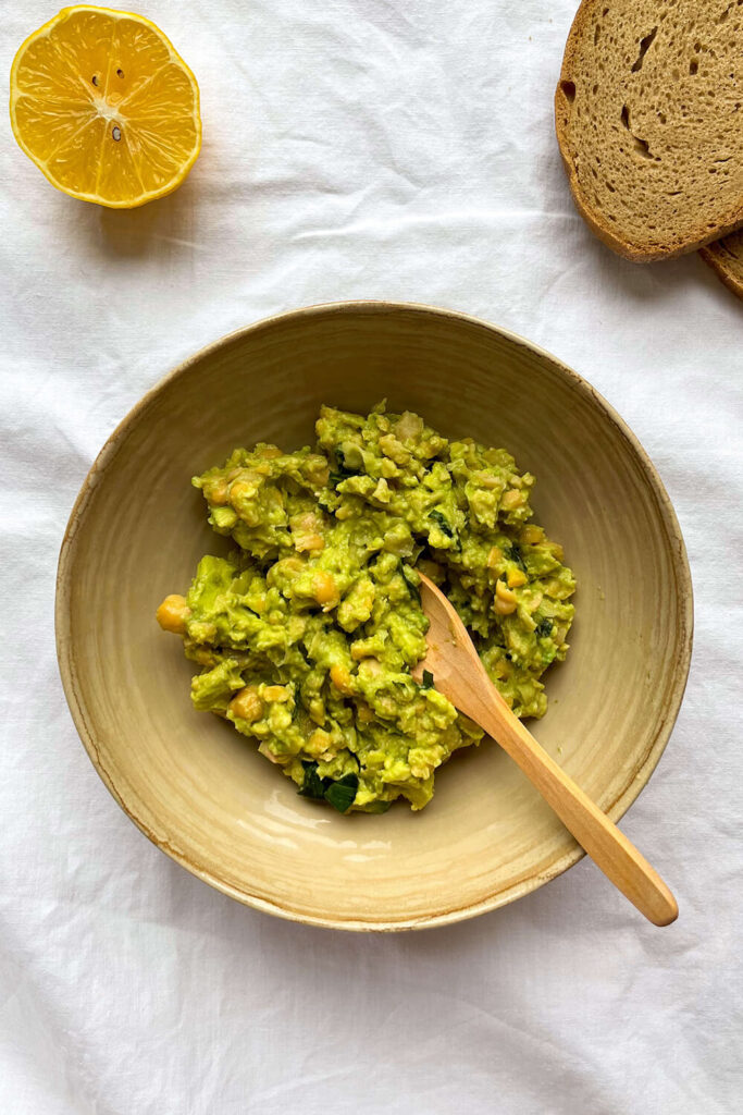 Mashing avocado, chickpeas, parsley, lemon, garlic powder, salt, and pepper.