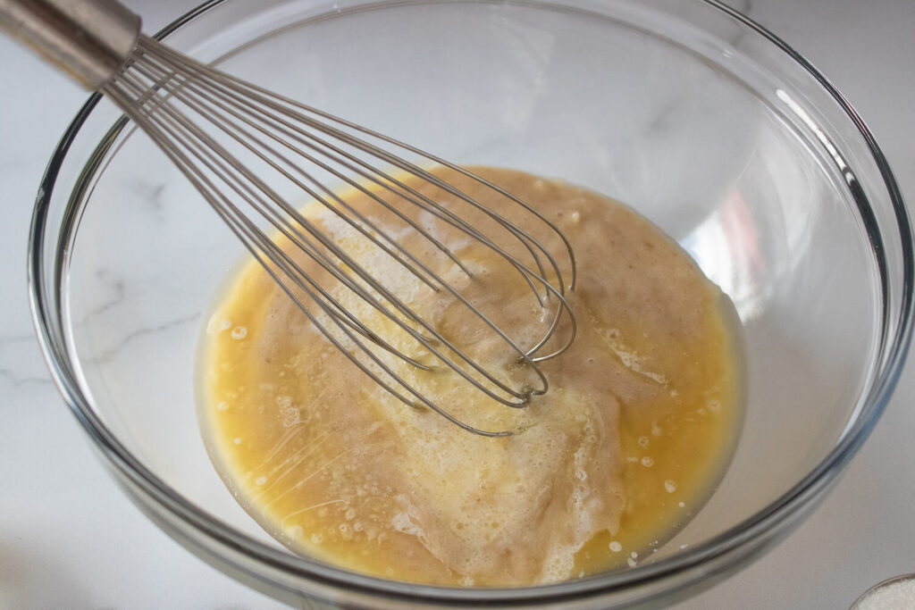 Combining mashed bananas, melted butter, and milk