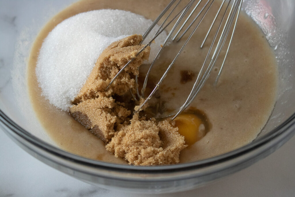 Adding the egg, vanilla extract, brown sugar, and granulated sugar