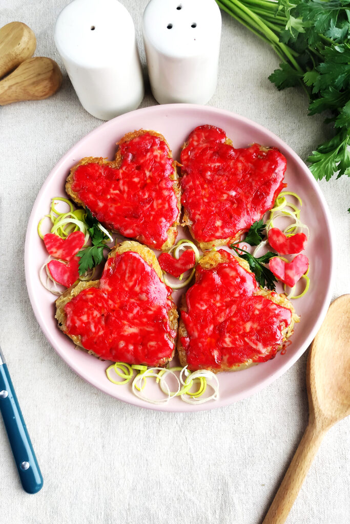 Serving the heart shaped red cheese hash browns with parsley and little cheese hearts