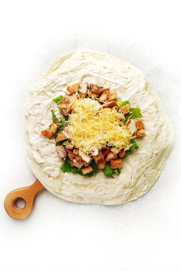 Adding more Caesar dressing and cheese