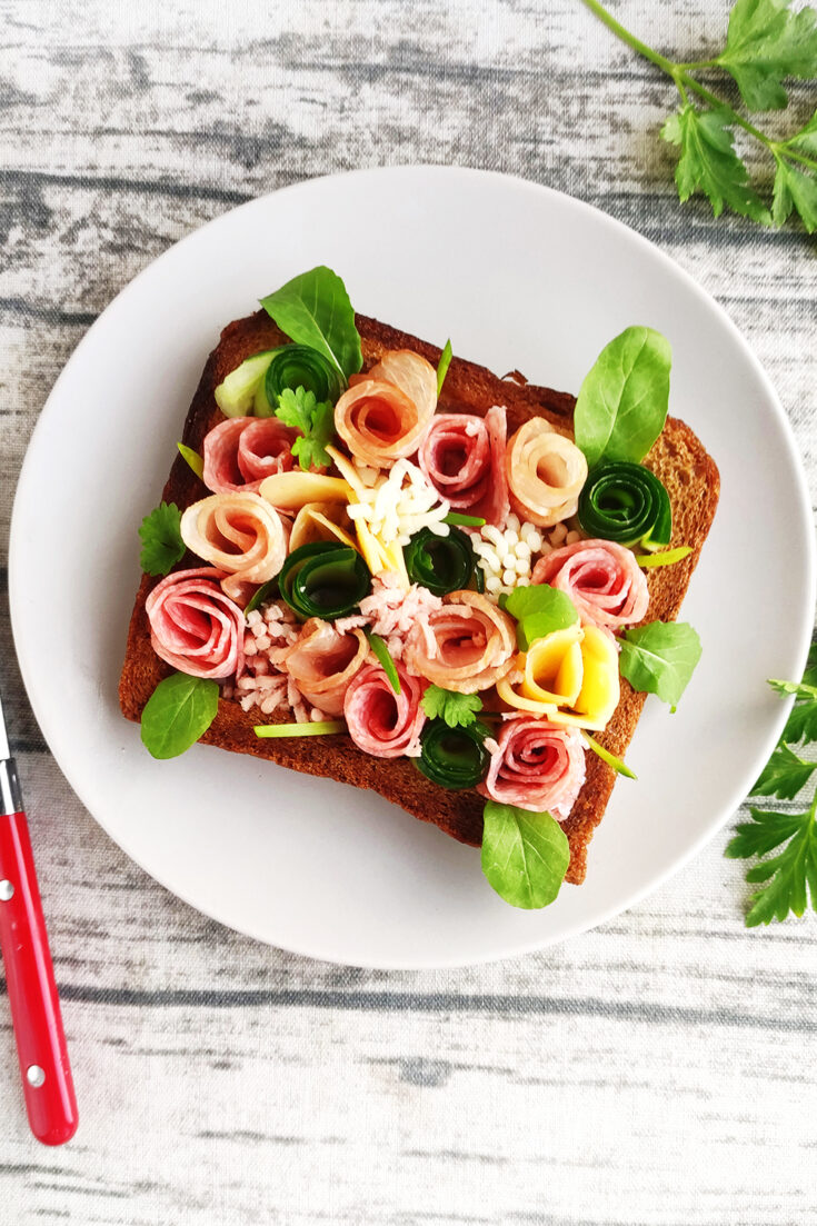Serve the garden-themed sandwich with fresh herbs on top