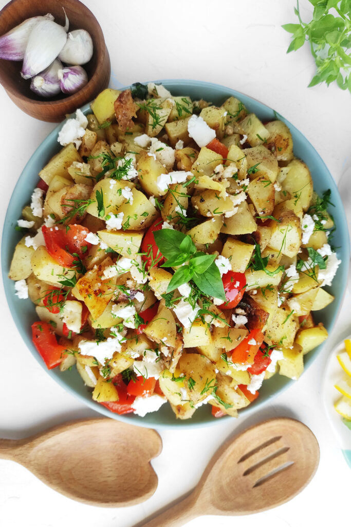 Serving Greek lemon potatoes with more feta cheese, chopped dill, and parsley
