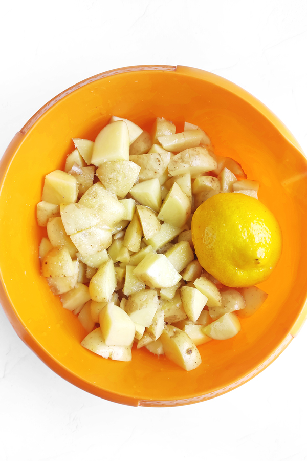 Mixing the potatoes with olive oil, lemon juice, and salt
