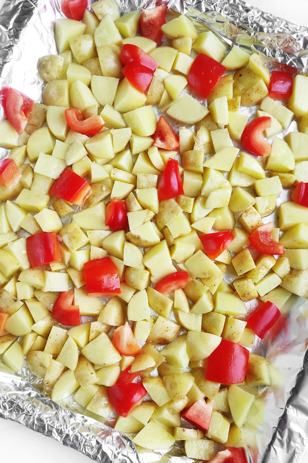 Spreading the potatoes and bell peppers on a baking tray
