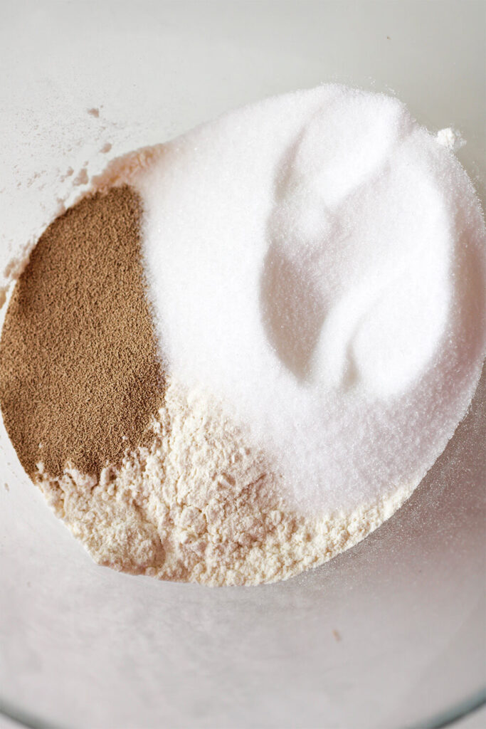 Mixing flour, yeast, and sugar.