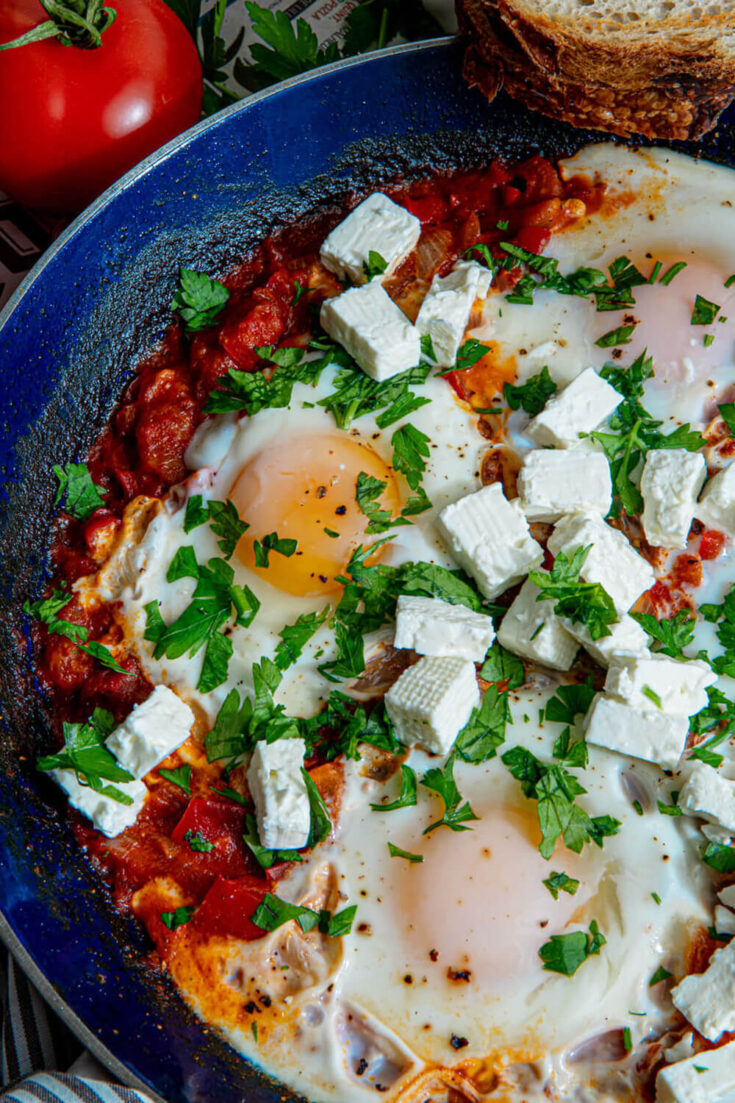 Serving the Shakshuka with crumbled feta and fresh parsley