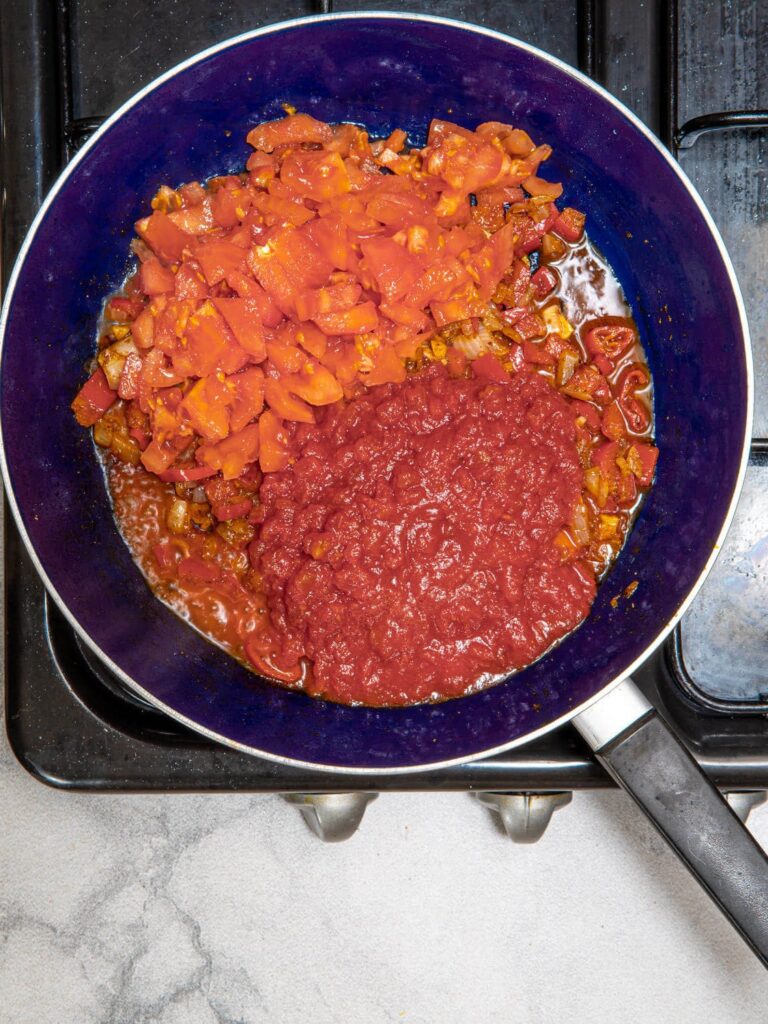 Pouring in diced tomatoes and tomato passata