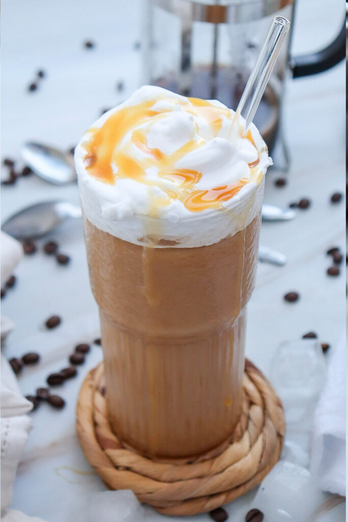 Serving the caramel iced coffee with a swirl of whipped cream and a drizzle of caramel sauce