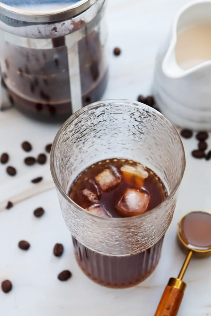 Pouring cooled coffee over ice cubes