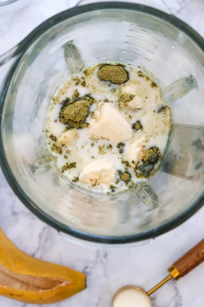 Blending almond milk, matcha, protein powder, sweetener, banana, and ice