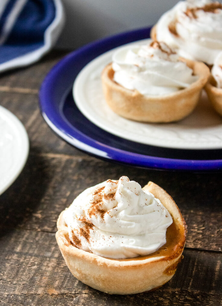 Serving the mini pumpkin pies with with whipped cream and a sprinkle of cinnamon