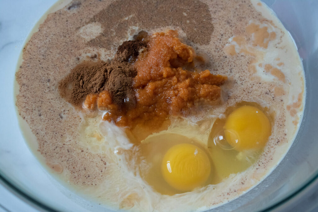 Mixing pumpkin puree, evaporated milk, brown sugar, eggs, and spices