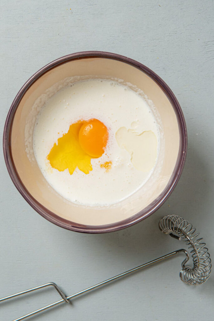 Mixing heavy cream, sour cream, vanilla extract, orange extract, and the egg