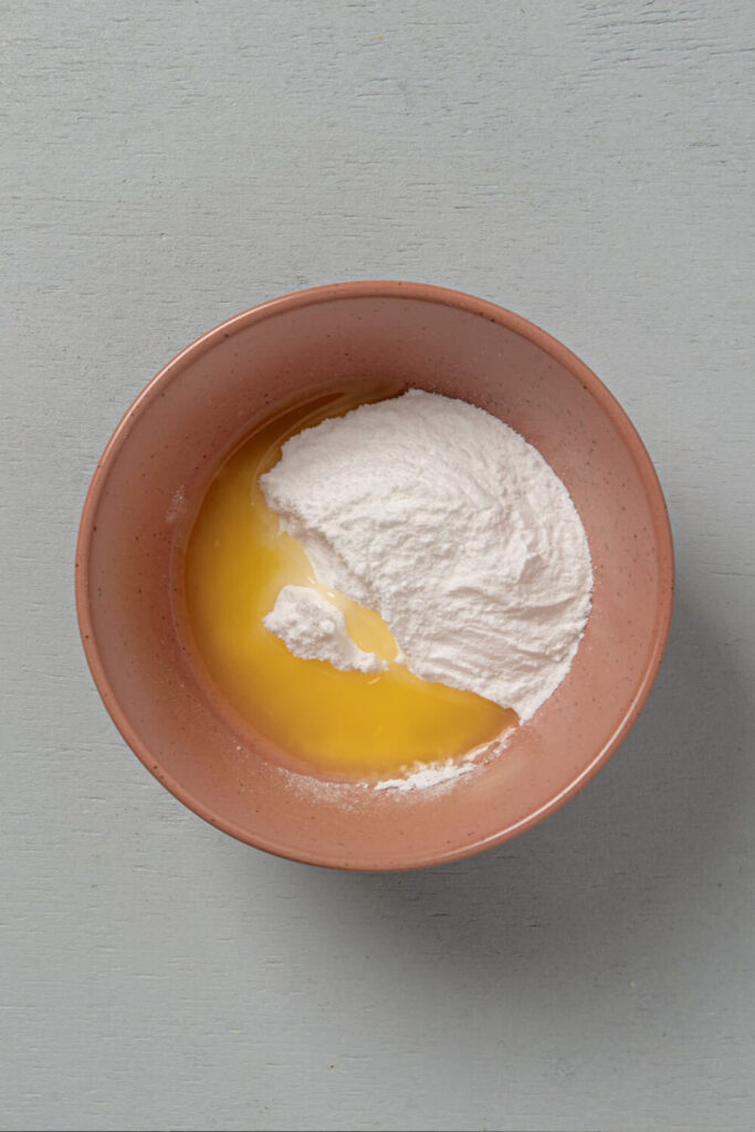 Mixing orange juice and powdered sugar
