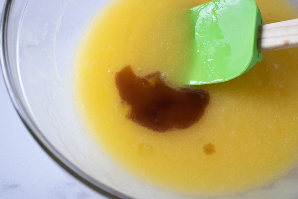 Mixing melted butter, sugar, eggs, and vanilla extract