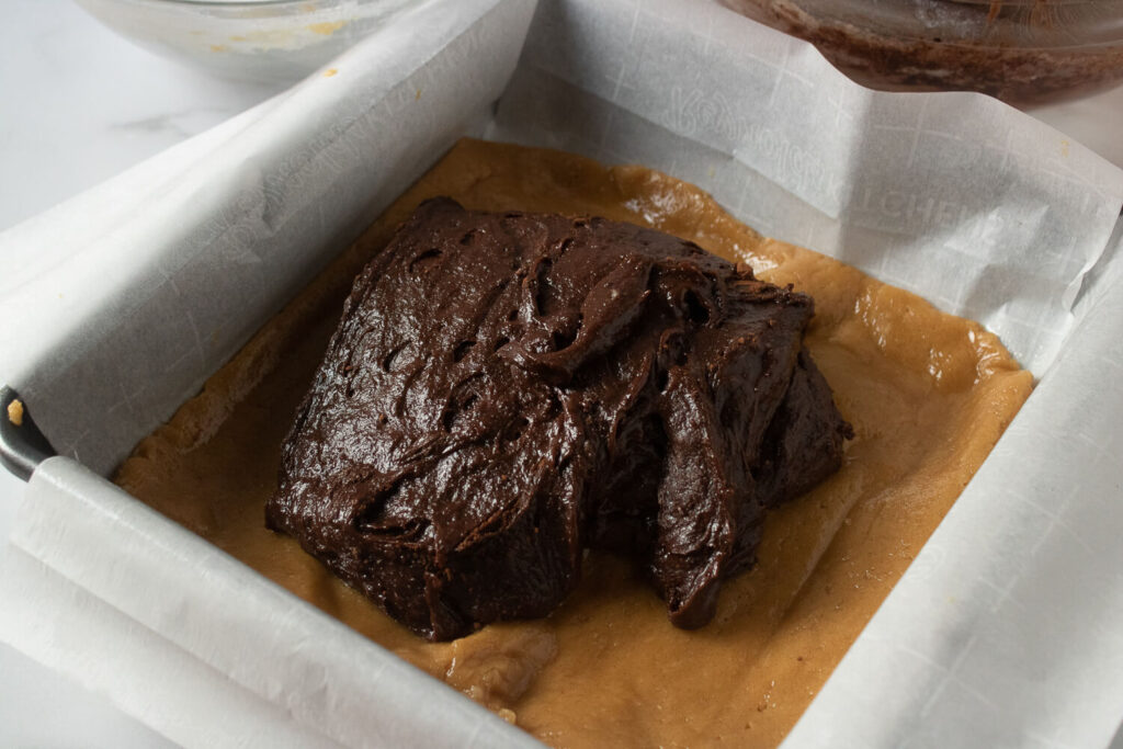 Spreading a chocolate layer on top of a peanut butter layer