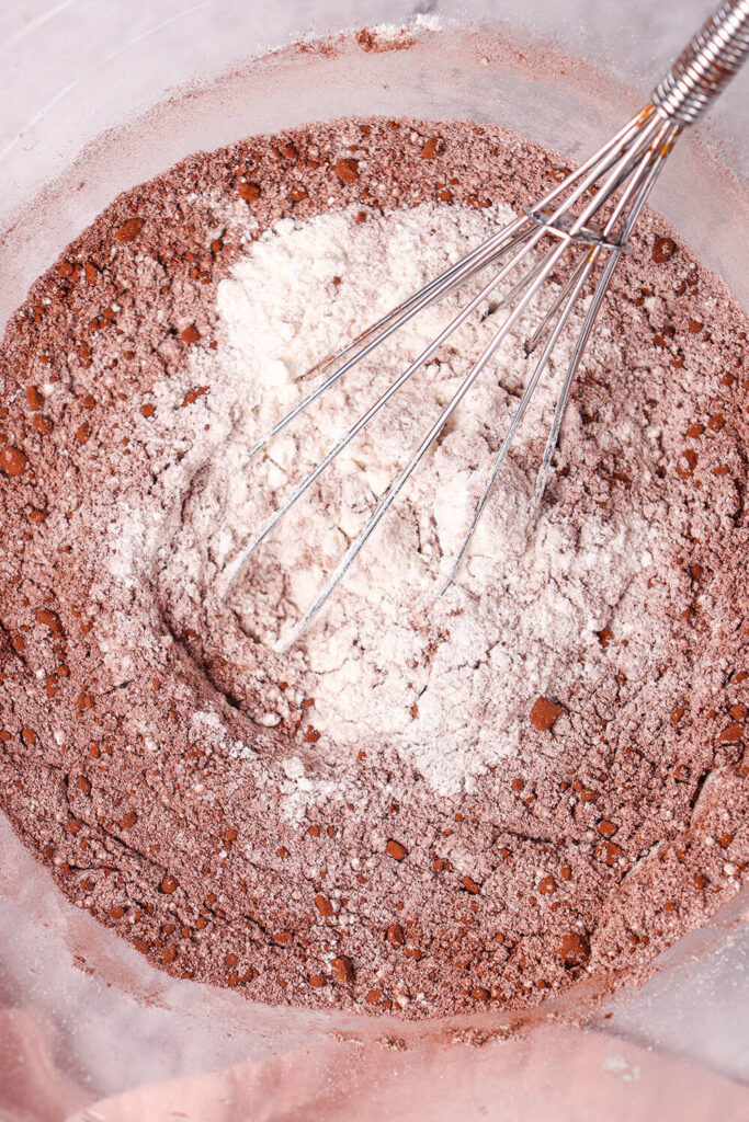 Mixing flour, sugar, cocoa powder, baking soda, and salt
