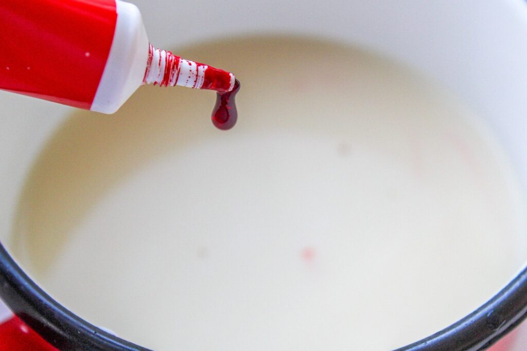 Adding drops of red food coloring